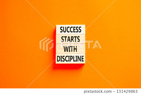 Success starts with discipline symbol. Concept words Success starts with discipline on beautiful wooden blocks. Beautiful orange background. Business success starts with discipline concept. Copy space 131429863