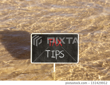 Tax tips symbol. Concept word Tax tips on beautiful black blackboard. Beautiful Red sea water background. Black blackboard. Business tax tips concept. Copy space. 131429912