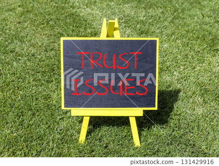 Trust issues symbol. Concept word Trust issues on beautiful black blackboard. Beautiful green grass lawn background. Black blackboard. Business trust issues concept. Copy space. Trust issues symbol. Concept word Trust issues on beautiful black blackboard. Beautiful green grass lawn background. Black blackboard. Business trust issues concept. Copy space. 131429916