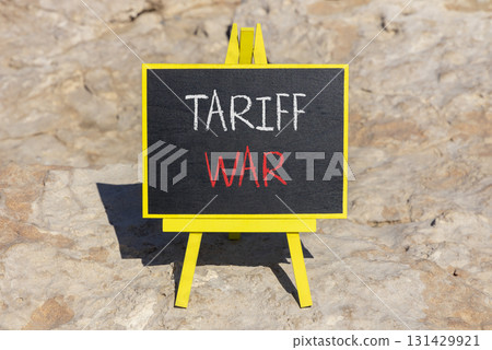 Trade tariff war symbol. Concept word Tariff war on beautiful black blackboard. Beautiful stone background. Black blackboard. Business trade tariff wars concept. Copy space. 131429921
