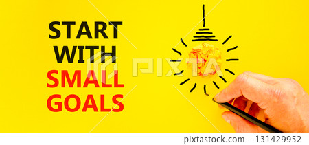 Start with small goals symbol. Concept words phrase Start with small goals on beautiful paper. Businessman's hand. Beautiful yellow background. Business Start with small goals concept. Copy space 131429952