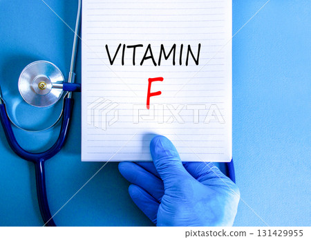 Vitamin F symbol. Concept words Vitamin F on beautiful white note. Doctor's hand in blue medical glove. Stethoscope. Beautiful blue background. Medical healthy lifestyle Vitamin F concept. 131429955