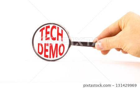 Tech demo symbol. Concept word Tech demo on beautiful magnifying glass. Businessman's hand. Beautiful white paper background. Black magnifying glass. Business tech demo concept. Copy space. Tech demo symbol. Concept word Tech demo on beautiful magnifying glass. Businessman's hand. Beautiful white paper background. Black magnifying glass. Business tech demo concept. Copy space. 131429969