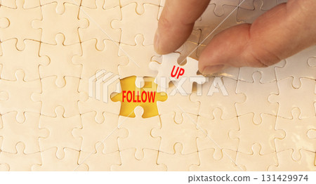 Follow up symbol. Concept word Follow up on beautiful white puzzles. Businessman's hand. Beautiful yellow paper background. Business follow up concept. Copy space. Follow up symbol. Concept word Follow up on beautiful white puzzles. Businessman's hand. Beautiful yellow paper background. Business follow up concept. Copy space. 131429974