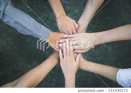 Top view of group of people team showing unity with putting their hands together in circle. Diversity hands join together for support and teamwork. Concept of teamwork. Top view of group of people team showing unity with putting their hands together in circle. Diversity hands join together for support and teamwork. Concept of teamwork. 131430273