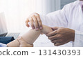 Orthopaedic doctor doing physical examination patient with wrist pain at the clinic. Physical therapist checks the patient wrist by pressing the wrist bone. 131430393