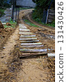 The road is unpaved, with a mix of dirt and small wooden planks, and it curves gently to the right.The mood is serene and rustic, evoking a sense of adventure or exploration in a natural setting. 131430426