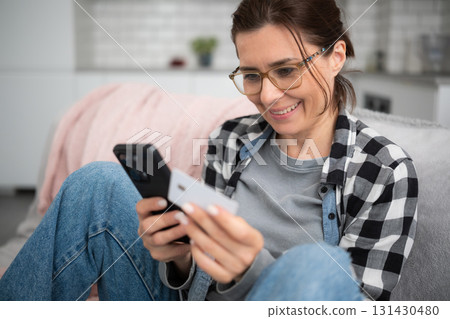 Young Woman Shopping Online With Smartphone Entering Card Data 131430480