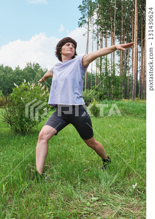 Mature woman practice yoga or pilates on lawn at park Mature woman practice yoga or pilates on lawn at park 131430624