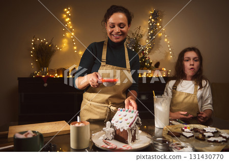 Joyful Mother And Kids Baking Christmas Gingerbread House At Cozy Home 131430770