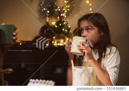 Girl Drinking Mug In Cozy Kitchen During Christmas With Holiday Decor And Warm Lights Girl Drinking Mug In Cozy Kitchen During Christmas With Holiday Decor And Warm Lights 131430865