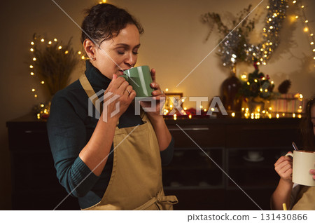 Cozy Christmas Kitchen Moment: Mother Sips Tea With Kids Amid Warm Holiday Decor Cozy Christmas Kitchen Moment: Mother Sips Tea With Kids Amid Warm Holiday Decor 131430866