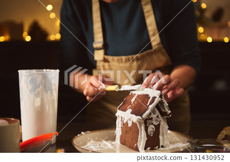 Family Christmas Gingerbread House Decorating By Cozy Fireplace In Warm Home Kitchen Scene 131430952