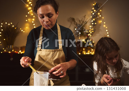 Warm Christmas Baking Moment With Mom And Daughter In Cozy Festive Kitchen Warm Christmas Baking Moment With Mom And Daughter In Cozy Festive Kitchen 131431008