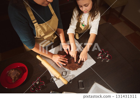 Mother And Daughter Baking Gingerbread Cookies Together In A Cozy Kitchen 131431311