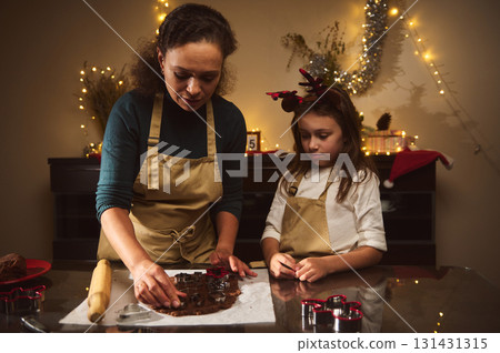 Mother And Daughter Bake Gingerbread House Together In A Cozy Christmas Kitchen Mother And Daughter Bake Gingerbread House Together In A Cozy Christmas Kitchen 131431315