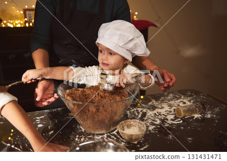 Little Chef Helps Bake Gingerbread As Family Festivities Glow In A Cozy Home Kitchen 131431471
