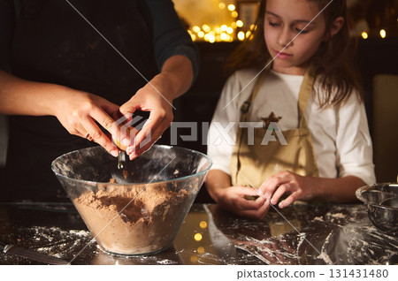 Mother And Daughter Bake Gingerbread Batter Together In Cozy Christmas Kitchen Mother And Daughter Bake Gingerbread Batter Together In Cozy Christmas Kitchen 131431480