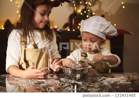 Two Kids Bake Gingerbread Together For Christmas, A Cozy Family Kitchen Scene 131431485