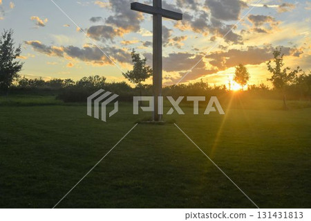 A great Christian cross in the landscape. A Christian cross highlighted by the sunset. The concept of religion and Christianity. A great Christian cross in the landscape. A Christian cross highlighted by the sunset. The concept of religion and Christianity. 131431813