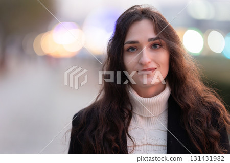 Young woman smiling with blurred city lights background Young woman smiling with blurred city lights background 131431982