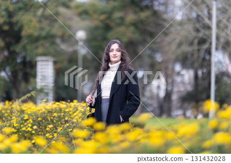 Young woman standing in blooming park enjoying nature Young woman standing in blooming park enjoying nature 131432028