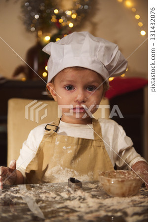 Young Child Chef in White Hat and Apron Baking Christmas Cookies at Home Kitchen Young Child Chef in White Hat and Apron Baking Christmas Cookies at Home Kitchen 131432076