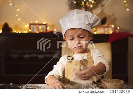 Young Chef Child Wearing Hat Baking Gingerbread House For Christmas In Cozy Home Kitchen Young Chef Child Wearing Hat Baking Gingerbread House For Christmas In Cozy Home Kitchen 131432079