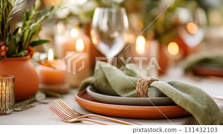 Elegant dining table set with green napkin, rustic plates, and candles, creating a warm atmosphere for gatherings and celebrations Elegant dining table set with green napkin, rustic plates, and candles, creating a warm atmosphere for gatherings and celebrations 131432103