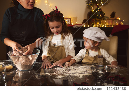 Family Christmas Baking Scene With Mother And Two Kids Decorating Gingerbread At Home 131432488