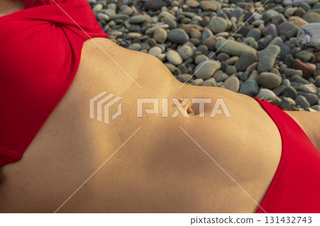 Close up shot of the flat woman belly with pierced bellybutton 131432743