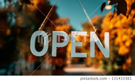 Word OPEN painted on glass window with blurred autumn trees in warm background 131433361