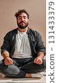 Plus-size Middle Eastern man meditating with closed eyes in cross-legged position on floor indoors 131433379