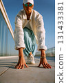 Low angle close-up of ultra plus-size East Asian woman in runner pose on rooftop under clear blue sky 131433381