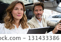 Young couple using tablet while sitting in car with sunroof 131433386