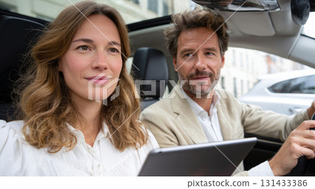 Young couple using tablet while sitting in car with sunroof 131433386
