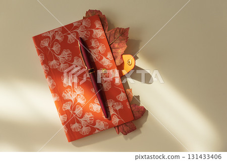 Autumn Notebook with Leaves and Pen on Light Background under Sun light Autumn Notebook with Leaves and Pen on Light Background under Sun light 131433406