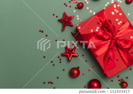Red Gift Box with Christmas Ornaments on Green Background Red Gift Box with Christmas Ornaments on Green Background 131433417