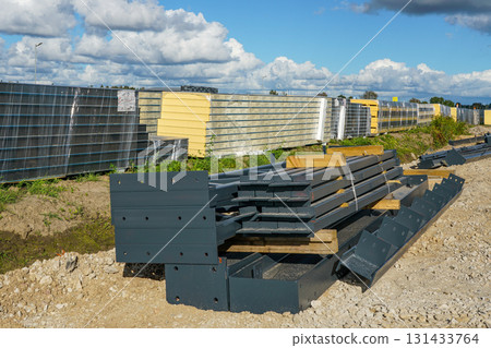 Sandwich wall panels and steel trusses stacked on construction site for modern building assembly 131433764