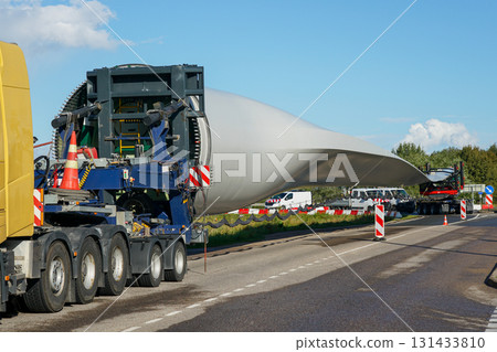 Oversized transport of massive wind turbine blade on special truck for renewable energy project Oversized transport of massive wind turbine blade on special truck for renewable energy project 131433810