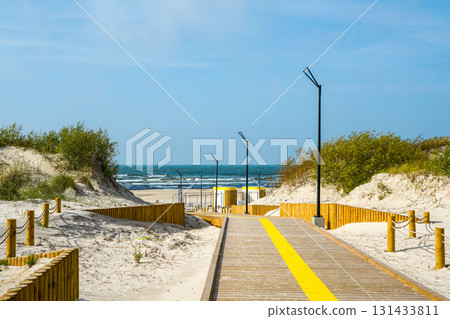 Modern wooden beach walkway with lights and dunes, Baltic Sea access, Liepaja, Latvia Modern wooden beach walkway with lights and dunes, Baltic Sea access, Liepaja, Latvia 131433811