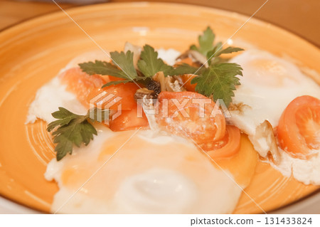 Fried eggs with tomato, mushroom, and parsley served on a plate for a healthy breakfast. Natural and fresh food concept. 131433824