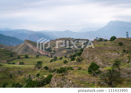 A mountain range with a cloudy sky in the background A mountain range with a cloudy sky in the background 131433995