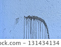 The coarse texture of a dark blue wall with a bold stain. The rough texture of a deep blue wall with an ink blot. The concept of background and textured surface. 131434134