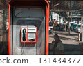Public telephone booth on street reflecting urban life 131434377