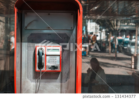 Public telephone booth on street reflecting urban life Public telephone booth on street reflecting urban life 131434377