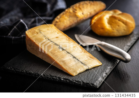 Morbier cheese. Delicious french cheese with mold on black table. Morbier cheese. Delicious french cheese with mold on black table. 131434435