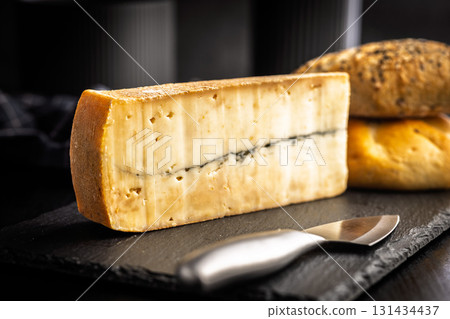 Morbier cheese. Delicious french cheese with mold on black table. Morbier cheese. Delicious french cheese with mold on black table. 131434437