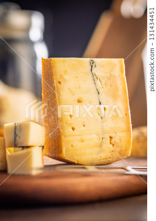 Morbier cheese. Delicious french cheese with mold on cutting board on wooden table. Morbier cheese. Delicious french cheese with mold on cutting board on wooden table. 131434451