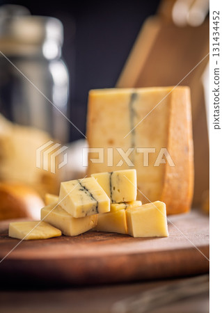 Morbier cheese. Delicious french cheese with mold on cutting board on wooden table. Morbier cheese. Delicious french cheese with mold on cutting board on wooden table. 131434452